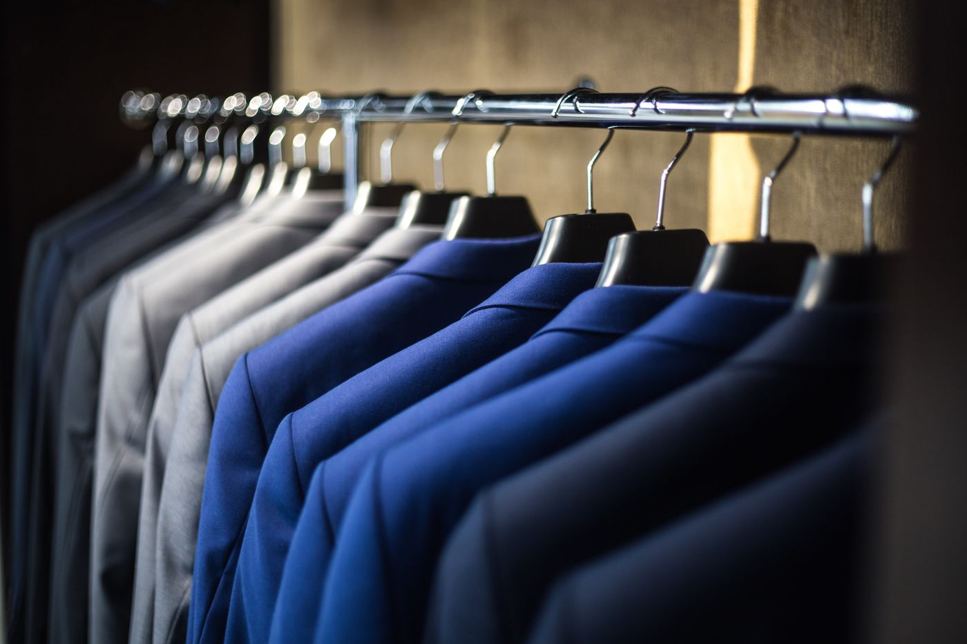 Rail of men's suit jackets in grey, blue and navy