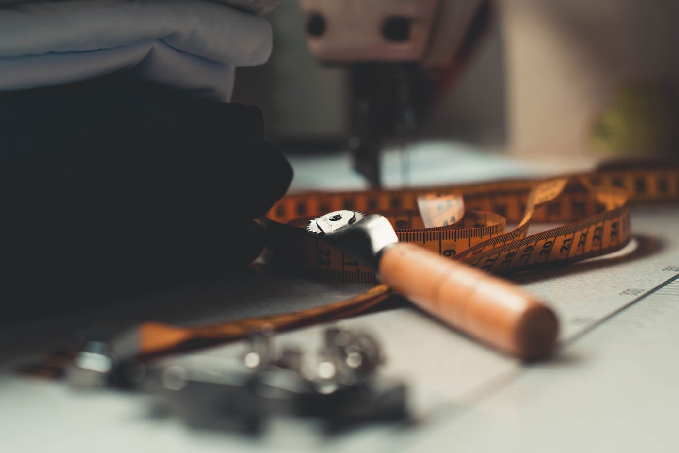 Tailoring bench with measuring tape, folded cloth and sewing tools