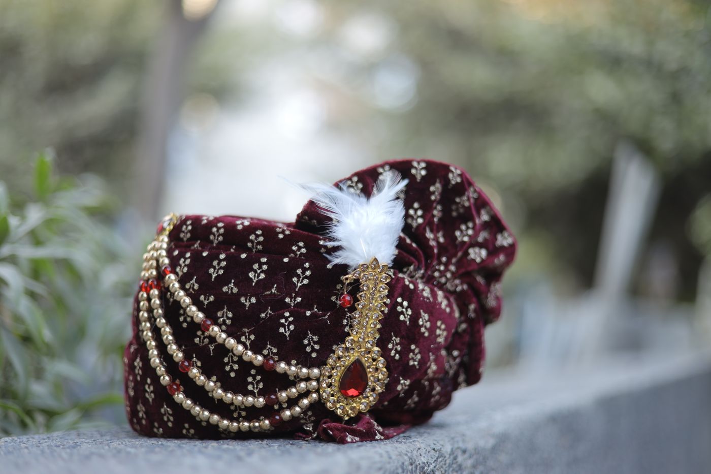 Maroon velvet safa with gold work, pearl strings and jewelled kalgi