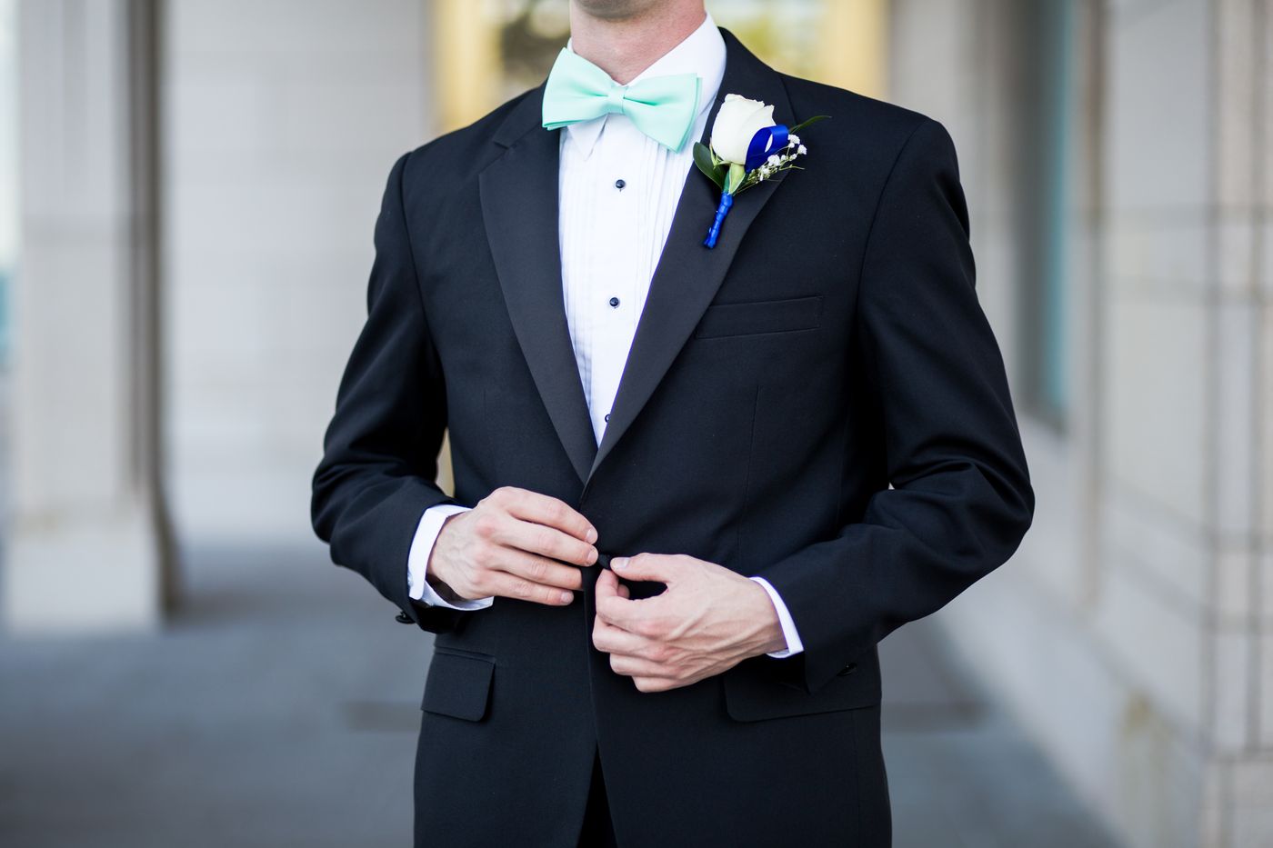 Black tuxedo with satin lapel, bow tie and rose boutonniere